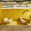 Das modulare noah Sofa als Teil eines Büros. Zwei Dreisitzer mit gelbem Bezug und gleichfarbigen Rahmen stehen sich gegenüber.