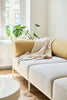 Das modulare noah Sofa in der Konfiguration 3-SITZER SOFA BREIT mit der Bezugfarbe Cremeweiss und Gestellfarbe Weiß steht in einem minimalistisch eingerichtetem Wohnzimmer.