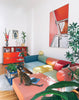 Modulares noah Sofa 3-SITZER MIT CHAISE ECKSOFA in bunt eingerichtetem Wohnzimmer. Die Bezüge haben unterschiedliche Farben. Die Gestellfarbe ist beigerot